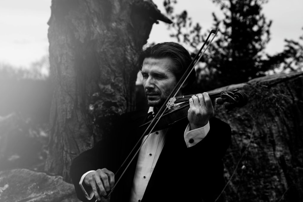 man playing violin in suit